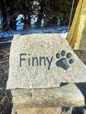 Engraved stone with paw print and name Finny